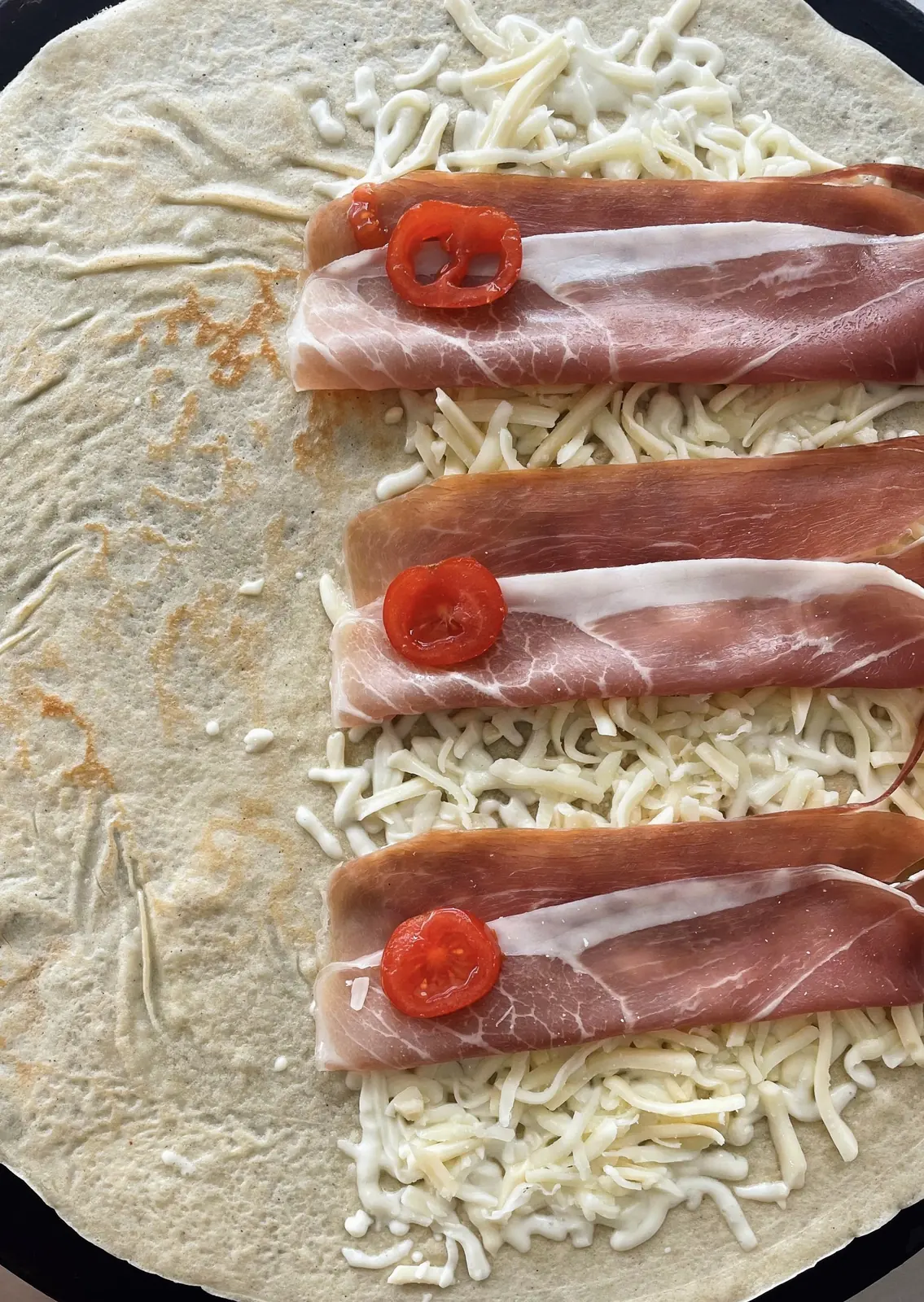 Crepe salada en preparación con mozzarella, prosciutto y tomates cherry en Fresh Ibiza